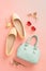 Fashion spring accessories for woman. Mint handbag and yellow ballet flats shoes on pastel pink