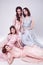 Fashion studio photo of four elgant women in pink and blue dress