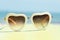 Fashion sunglasses heart shaped on yellow stand with blue sea background
