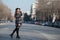 Fashion teen walking in profile in the middle of the highway