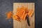 A fashion trend is eating deformed and ugly vegetables. Food waste reduction. Grated carrots on a cutting board. Copy space