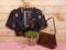Fashion trends - black crop top / blouse in floral print on hangs on hanger, bag and jewelry: hair pearl clip, necklace, earrings