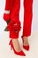 Fashion unrecognizable Lady legs in red pants and shoes.  Flowers decor. Minimalist elegant details style