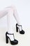 Fashion unrecognizable Model legs in white tights and black Lady shoes. Minimalist elegant paris details style. Retro vintage