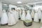 Fashion wedding dresses on hanger and mannequins in salon