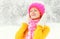 Fashion winter portrait happy woman wearing colorful knitted hat sweater scarf enjoys over snowy