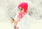 Fashion winter woman using smartphone wearing colorful knitted hat scarf over snowy