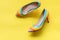 Fashion woman accessories set. Trendy fashion colorful shoes heels. Yellow pastel color background, top view and copy space.
