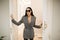 Fashion woman enters the room door. Business suit and sunglasses