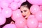 Fashion woman with many pink air balloons. Birthday decor and celebration. girl dreaming in punchy pastels trend. Retro