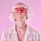 Fashion, woman and quirky on a pink background in studio with funny glasses for cyberpunk style. Face of edgy, trendy or