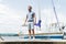 Fashion young man portrait at river and yachts on background. sailor with yacht. Man portrait against yachts with folded sail.