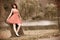 Fashion young woman in red dress relaxing in park