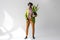 fashionable african american man in hat with green plant in flowerpot in hand posing