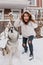 Fashionable amazing girl having fun with cute husky dog outdoor in snow. Happy winter time of real friends, home pets