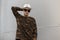 Fashionable american hipster man in a straw vintage hat with dark sunglasses in a trendy military shirt posing