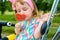 Fashionable baby girl, sunglasses, lollipop like a heart. Happy children hold candy green grass outdoors. Candy shop. Lollipop or