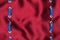 Fashionable beautiful background, blue satin ribbon inserted in red satin fabric