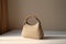 Fashionable beige leather clutch bag on a white table