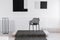 Fashionable black industrial chair in the middle of monochrome interior