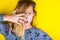 Fashionable blond girl with British manicure on yellow background