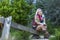 Fashionable blonde woman sitting in a Park on an old wooden swing.