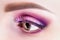 Fashionable bright eye makeup close-up. Female eye with pink violet shadows and false eyelashes