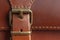 Fashionable brown women`s bag made of genuine leather close-up. Fashion concept. Details of leather bag, belt, metal buckle, clas