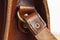 Fashionable brown women`s bag made of genuine leather close-up. Fashion concept. Details of leather bag, belt, metal buckle, clas