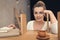 Fashionable businesswoman standing at bookshelf with coffee cup in modern office