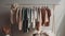 Fashionable clothing collection hanging on coathangers in a clean closet generated by AI