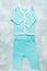 Fashionable cotton textile summer suit for newborn baby on blue textured background. Flat lay style