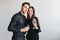 Fashionable dark-haired lady with gentle smile leaning to her husband while posing at party. Handsome man in black suit