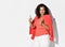 Fashionable elegant satisfied woman model with long curly hair in vibrant formal elegant suit showing approval thumbs-up gesture