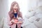 Fashionable freak. Portrait of glamour happy beautiful woman with long lilac hair is holding colorful donut on the plate