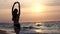 Fashionable girl in a black swimsuit enters the sea at sunset. I am happy with the sea and the beach. Experiencing