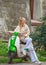 Fashionable girl in coat and black glasses on retro moped on the street of an old European city