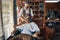 Fashionable hairdresser shaving his customer with an axe