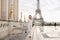 Fashionable lady walking on Trocadero square near gilded statues and Eiffel Tower.