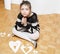 fashionable little girl sitting and dreaming on hardwood floor with paper hearts cut for valentines day
