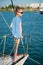 Fashionable little kid aboard luxury boat in summer sea cruise