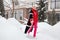 Fashionable mature woman near winter villa house, wealthy, stylish and happy aged female walking at snow near home. Short hair