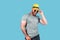 Fashionable muscular bearded emotional man in yellow straw hat posing in studio over blue background