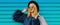 Fashionable portrait stylish blonde woman with two shopping bags wearing a blue faux fur coat, black round hat on colorful