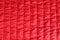 Fashionable quilted fabric in red color. Abstract background