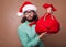 Fashionable Santa Claus derided holding a bag with gifts