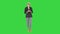 Fashionable senior grey-haired woman in glasses talking to camera on a Green Screen, Chroma Key.