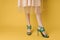 Fashionable shoes green shoes female feet shopping yellow background