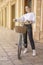 Fashionable sicilian girl with bicycle in a baroque arcade in sicily