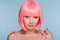 Fashionable smiling young woman posing in pink wig isolated